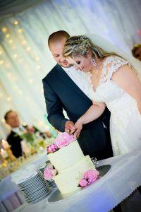 Novomanželia rozkrajujú svadobnú tortu od Koláčikovo Zuzana.
