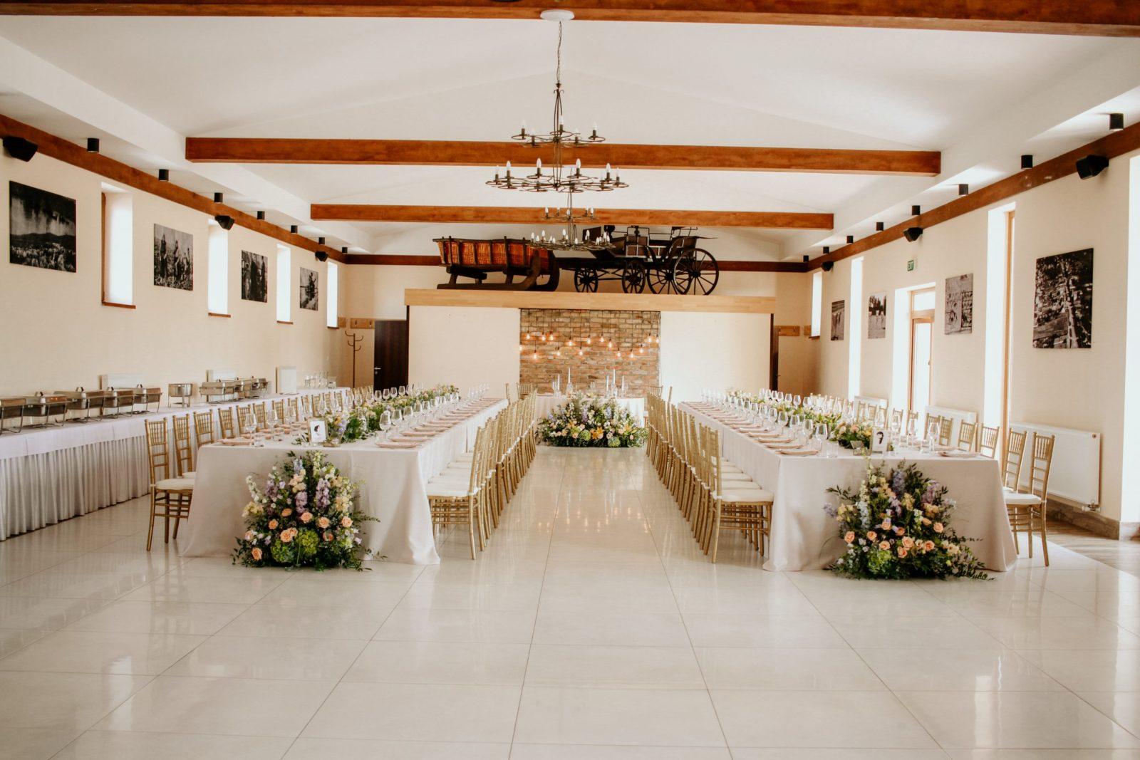Kombinácia podlhovastých stolov a hlavného okrúhleho stola novomanželov. Svadobná výzdoba od Eventia.